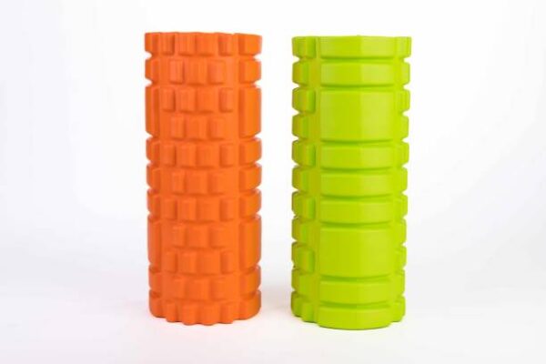 Athletic massage roller orange and green color isolated on white background.